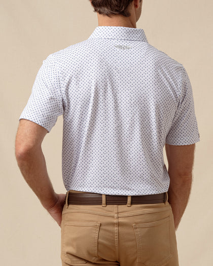 Back view of men’s white geometric print polo shirt paired with tan pants