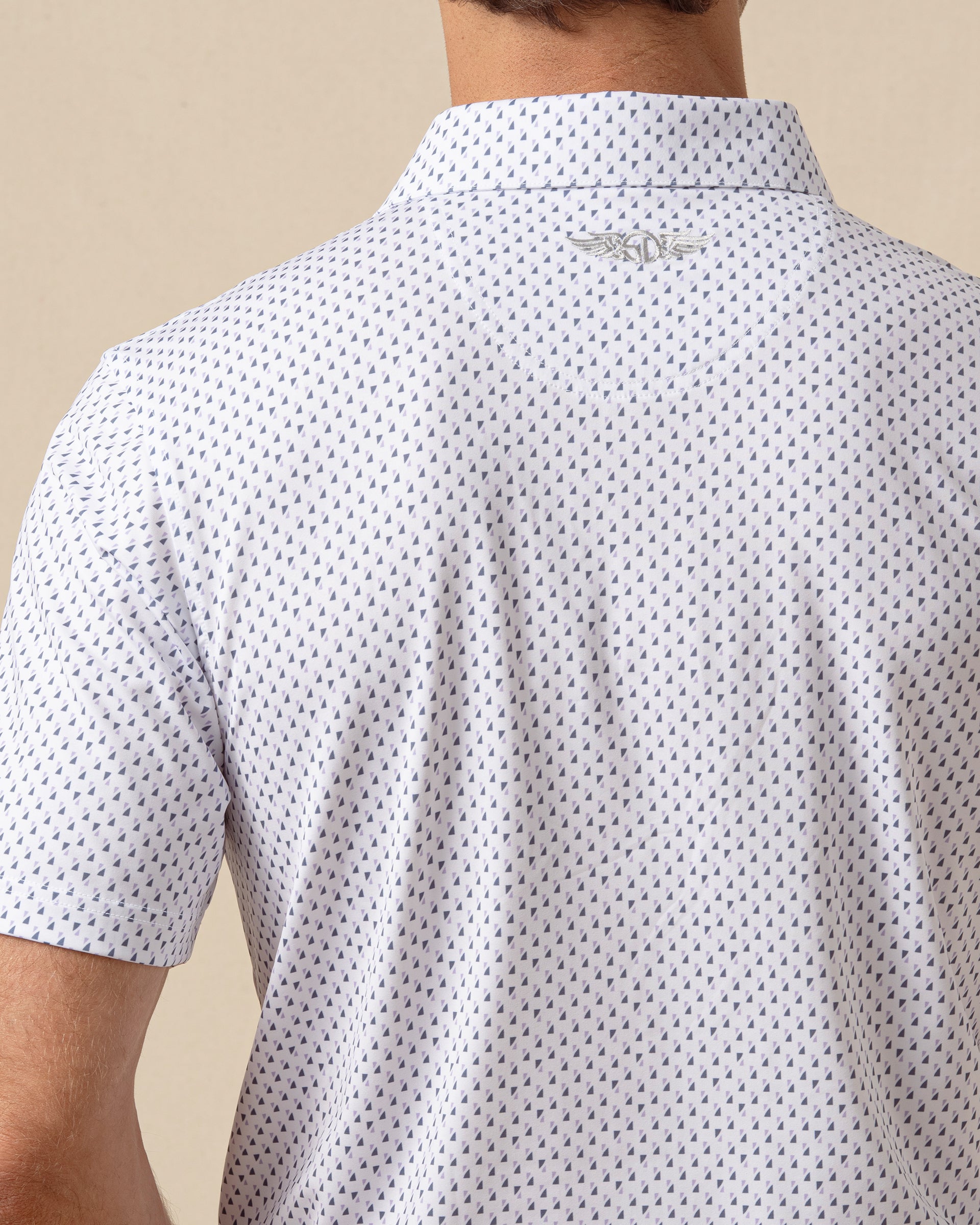 Back view detail of white geometric print polo shirt featuring logo below the collar