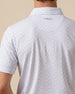 Back view detail of white geometric print polo shirt featuring logo below the collar