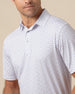 Close-up of white polo shirt with subtle geometric print highlighting collar and button placket