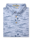 Men's Outrigger Polo in Powder, folded flat lay front view featuring a light blue Hawaiian toile print with palm trees, waves, and outrigger canoes with wood buttons