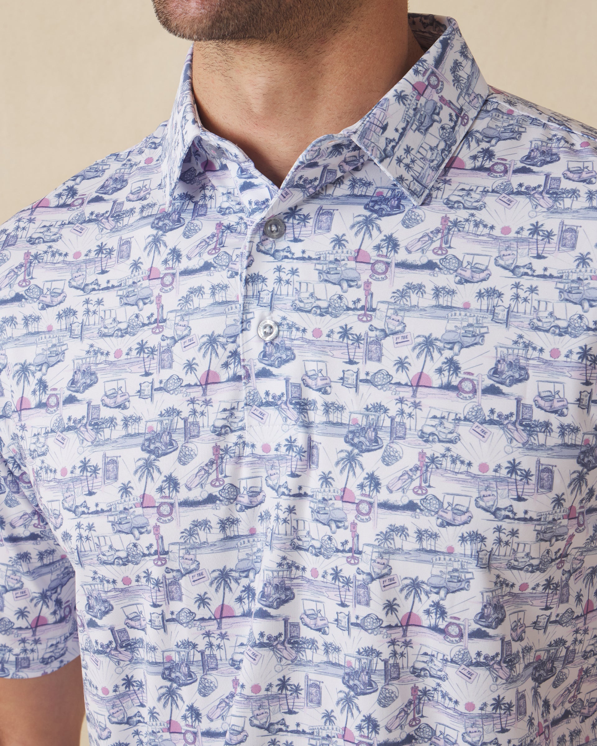 Close-up of polo collar and button placket with blue and pink tropical golf print