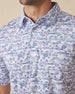 Close-up of polo collar and button placket with blue and pink tropical golf print