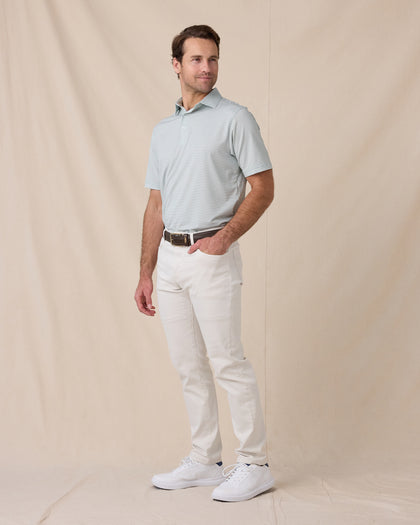Model wearing the Campus Stripe Polo in Herb with white pants, a brown belt, and white sneakers.