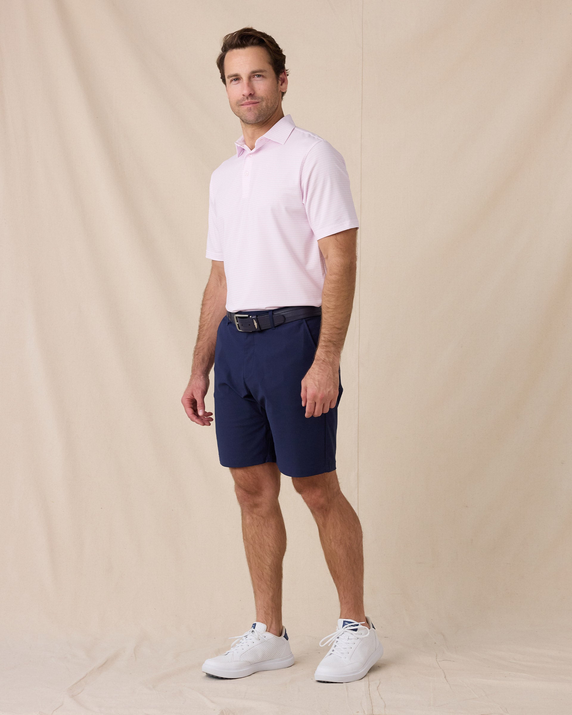 Model styled in the Campus Stripe Polo in lilac paired with navy shorts and white sneakers