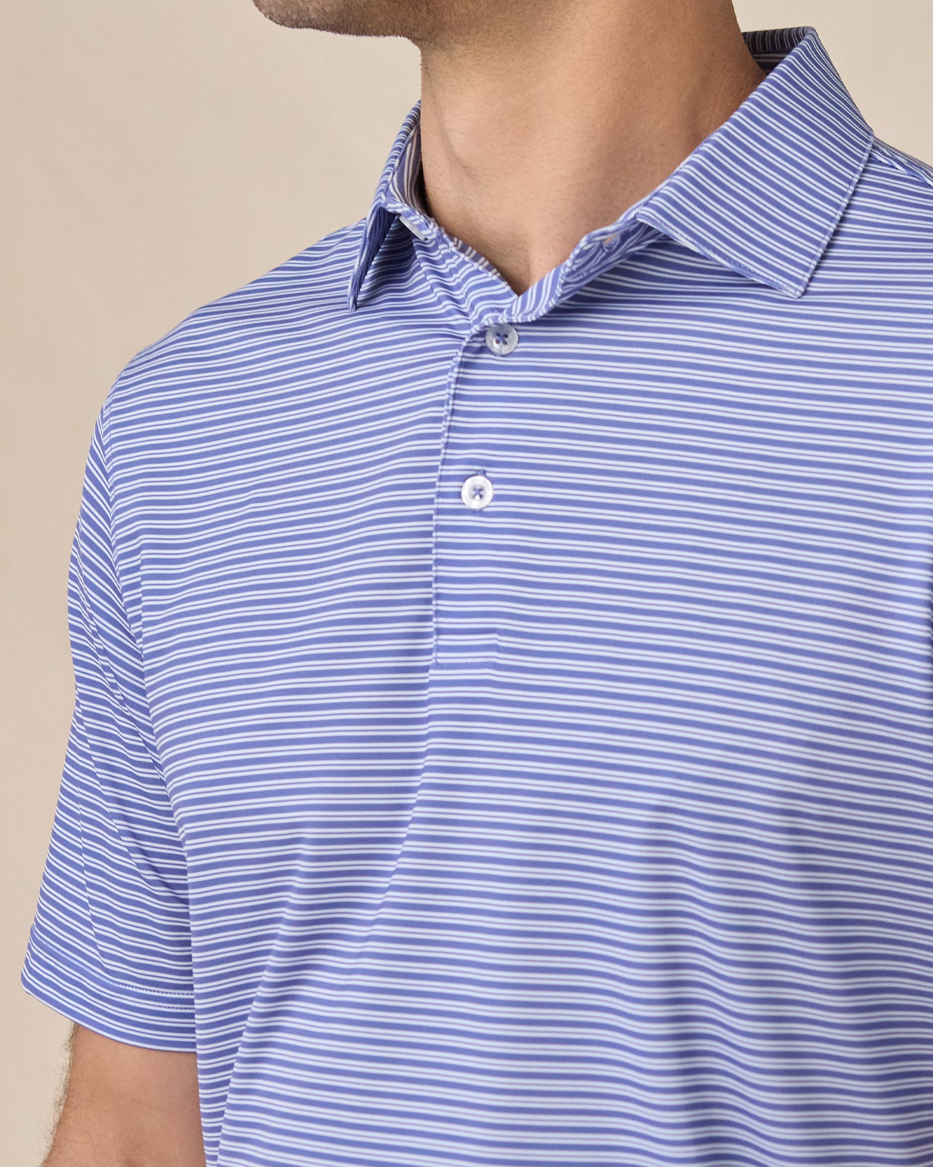 Close-up of the Campus Stripe Polo in Tidal Blue highlighting the self-collar, three-button placket, and blue and white stripe pattern