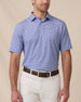 Model wearing the Campus Stripe Polo in Tidal Blue with light-colored pants, showcasing the classic striped design