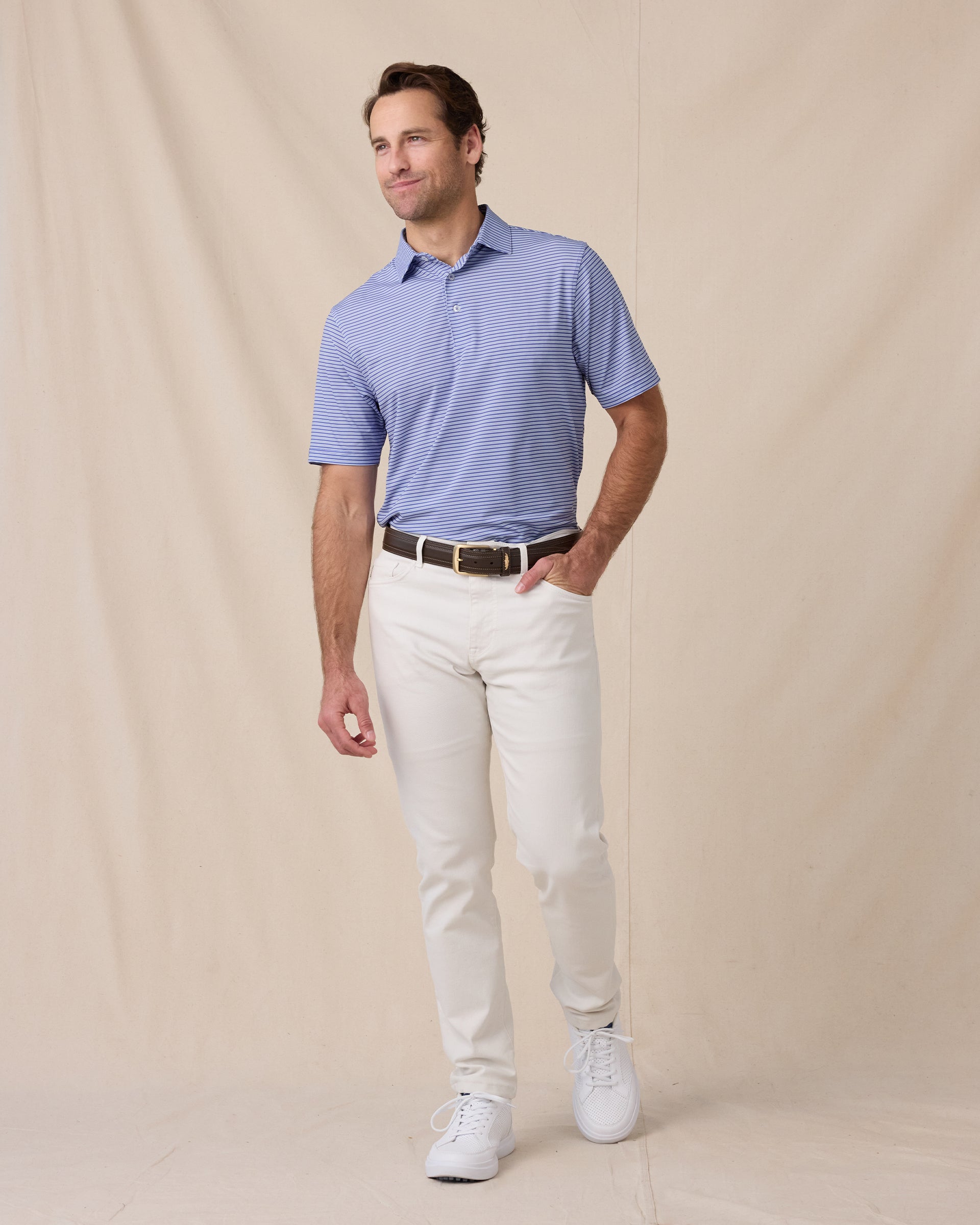 Model styled in the Campus Stripe Polo in Tidal Blue paired with light pants and white sneakers