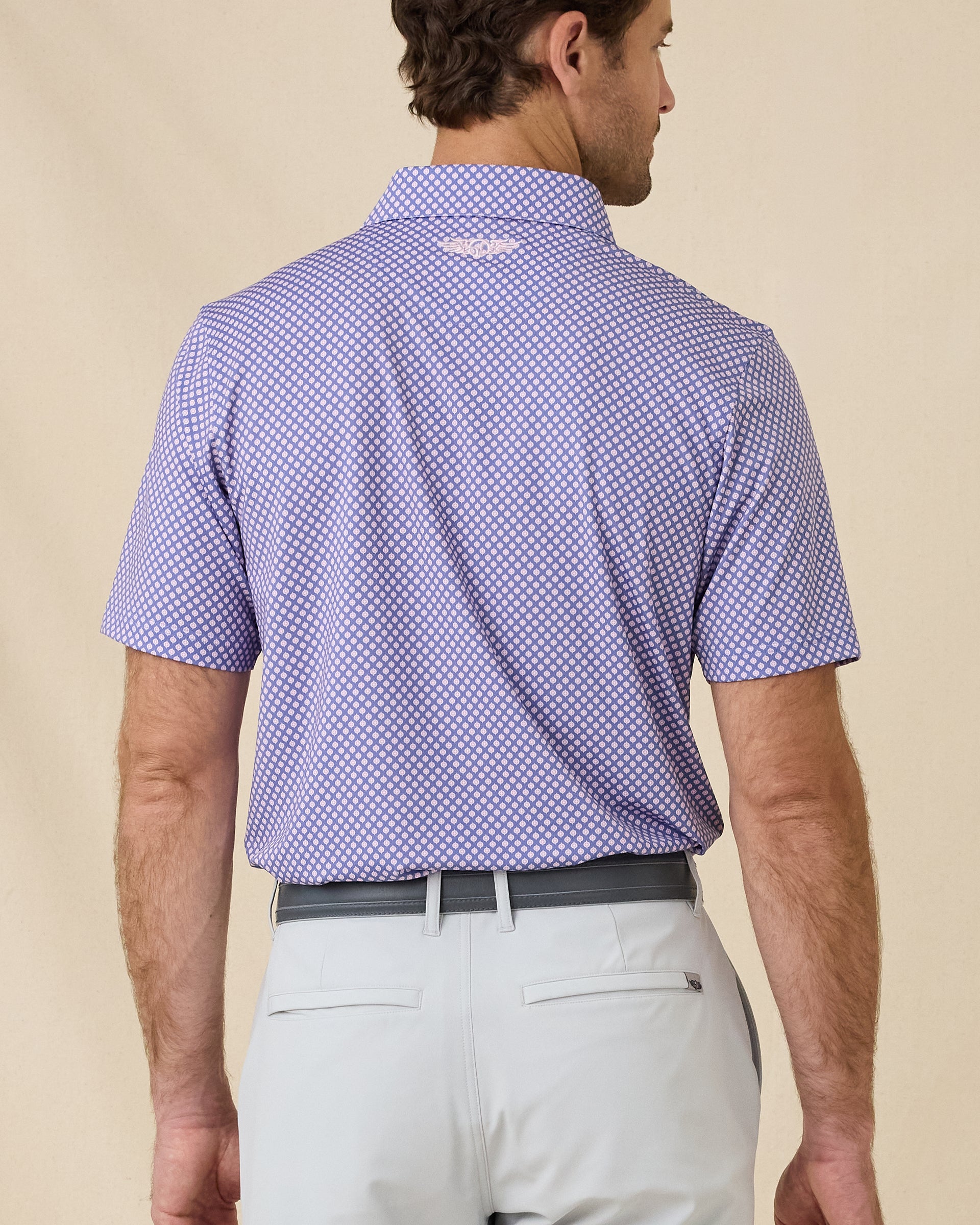 Back view of the Ironwood Polo in tidal blue featuring the all-over geometric print and embroidered Straight Down logo below the collar