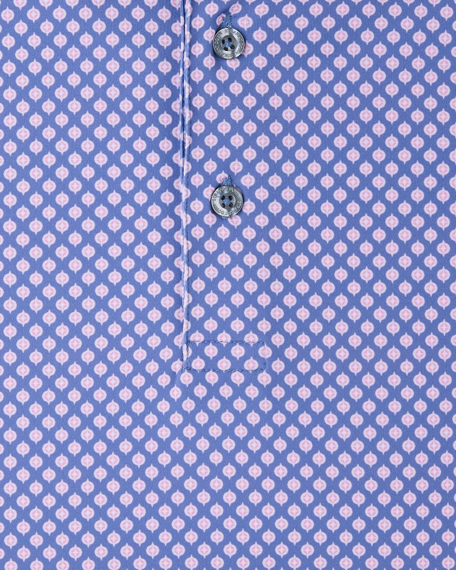 Close-up of the Ironwood Polo in tidal blue highlighting the pink geometric print and branded buttons
