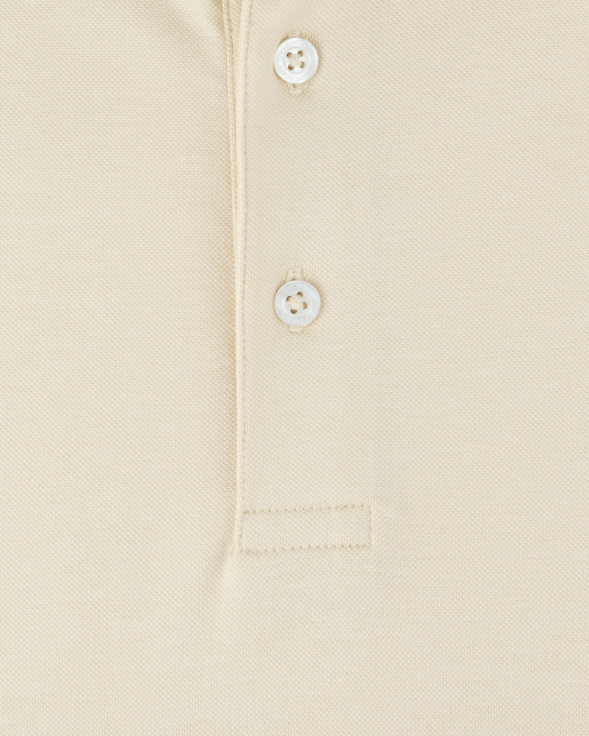 Close-up of the Oxford Polo in Summer Sand, showcasing the textured fabric, two Straight Down branded buttons, and reinforced placket stitching.