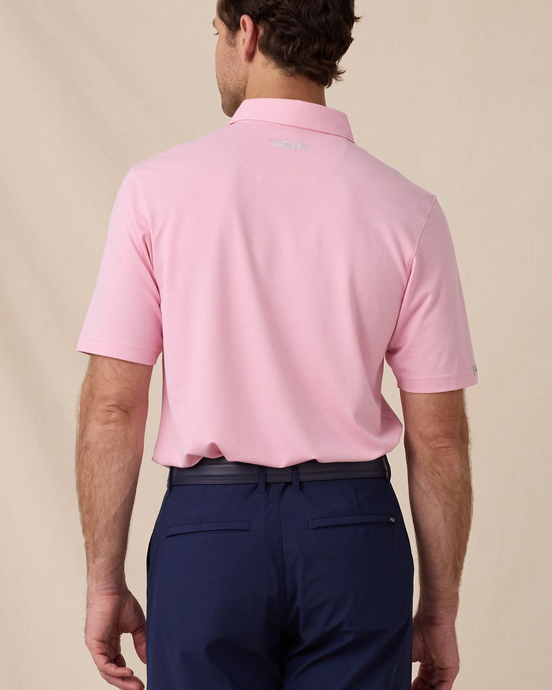 Back view of the Oxford Polo in punch pink featuring a clean silhouette and embroidered Straight Down logo at the neck