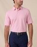 Model wearing the Oxford Polo in punch pink paired with navy bottoms