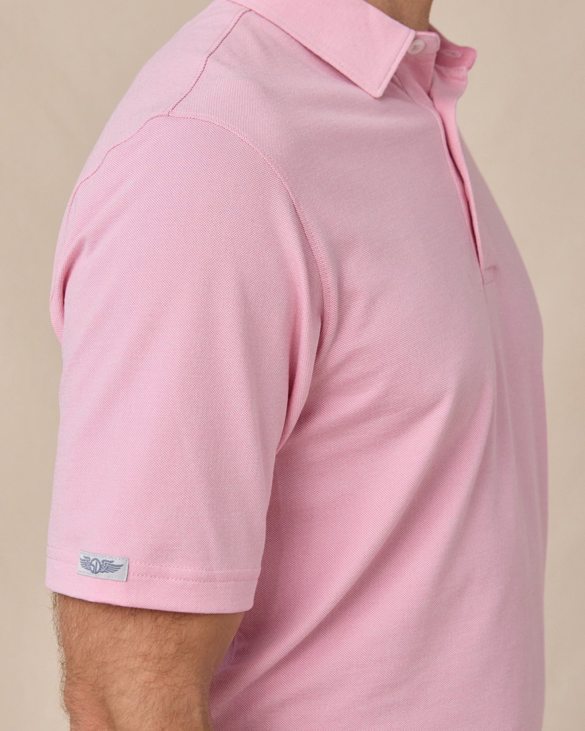 Sleeve tag detail of the Oxford Polo in punch pink