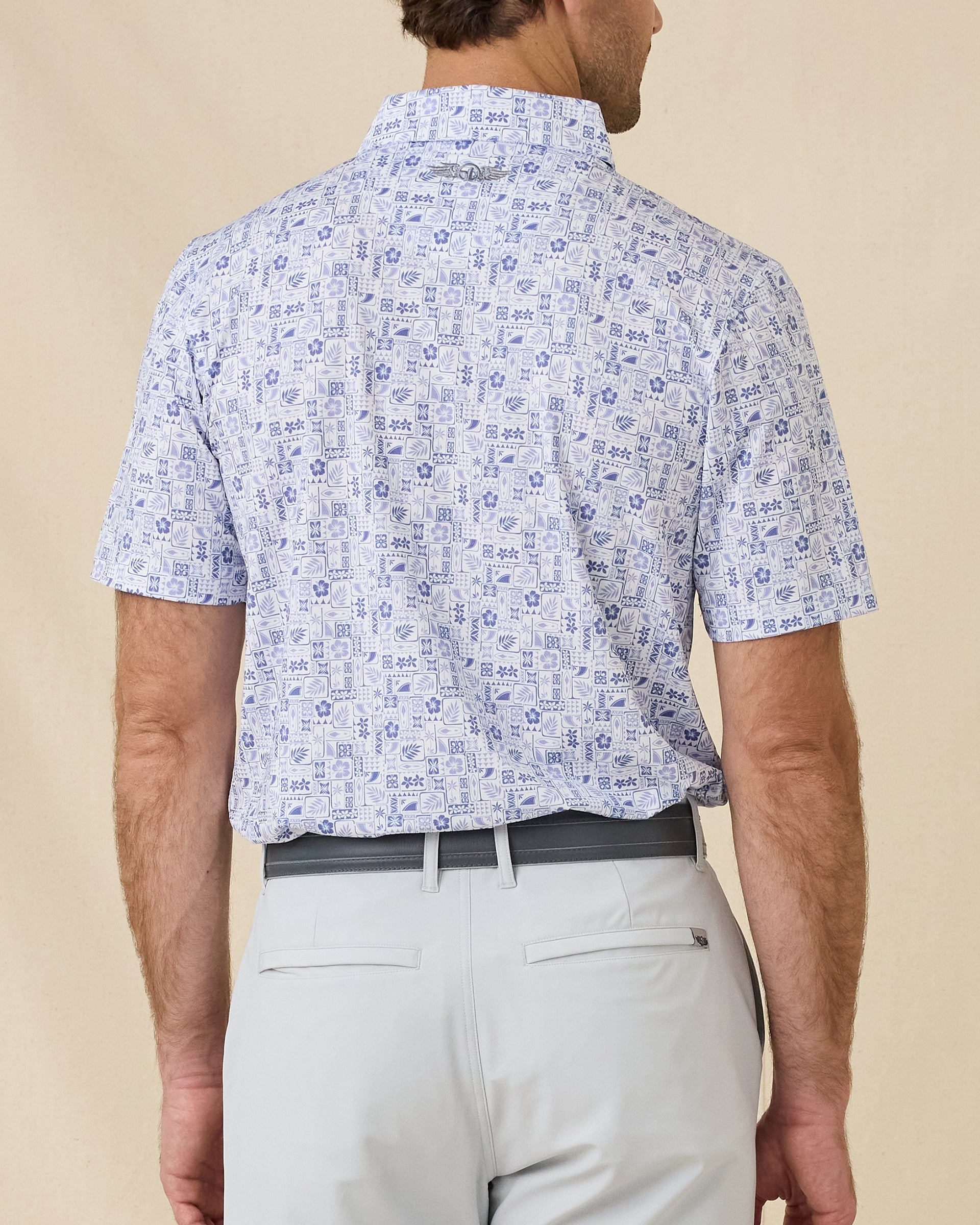 Back view of the Waterman Polo in Tidal Blue featuring a continuous tropical tile pattern