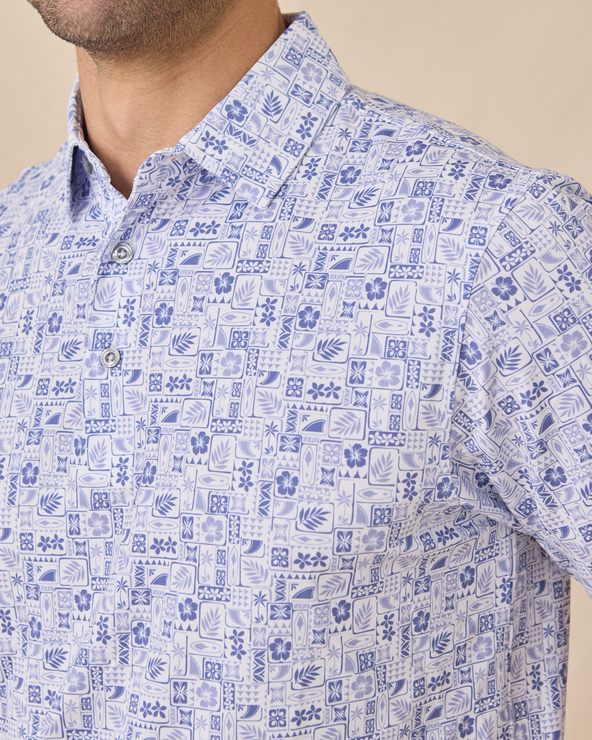 Close-up chest view of the Waterman Polo in Tidal Blue showcasing the detailed island-inspired tile print