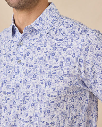 Close-up chest view of the Waterman Polo in Tidal Blue showcasing the detailed island-inspired tile print