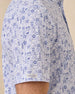 Side detail of the Waterman Polo in Tidal Blue showing the allover island tile print and Straight Down sleeve logo