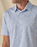 Close-up of the Tropics Lounge Polo in Blue Shade, highlighting the intricate botanical print, collar, and button placket.