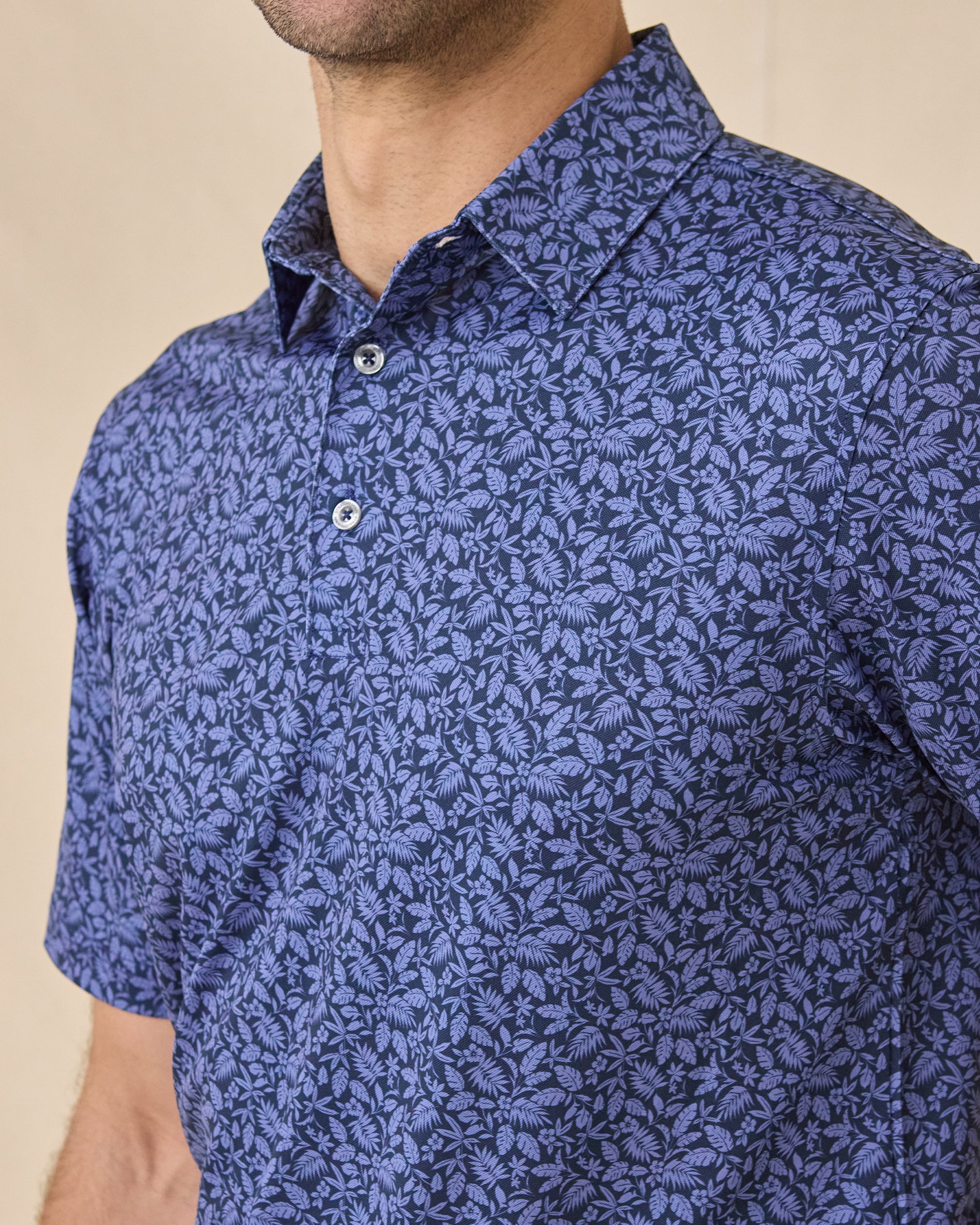 Close-up chest view of the Tropics Lounge Polo in Tidal Blue showcasing the intricate tropical print