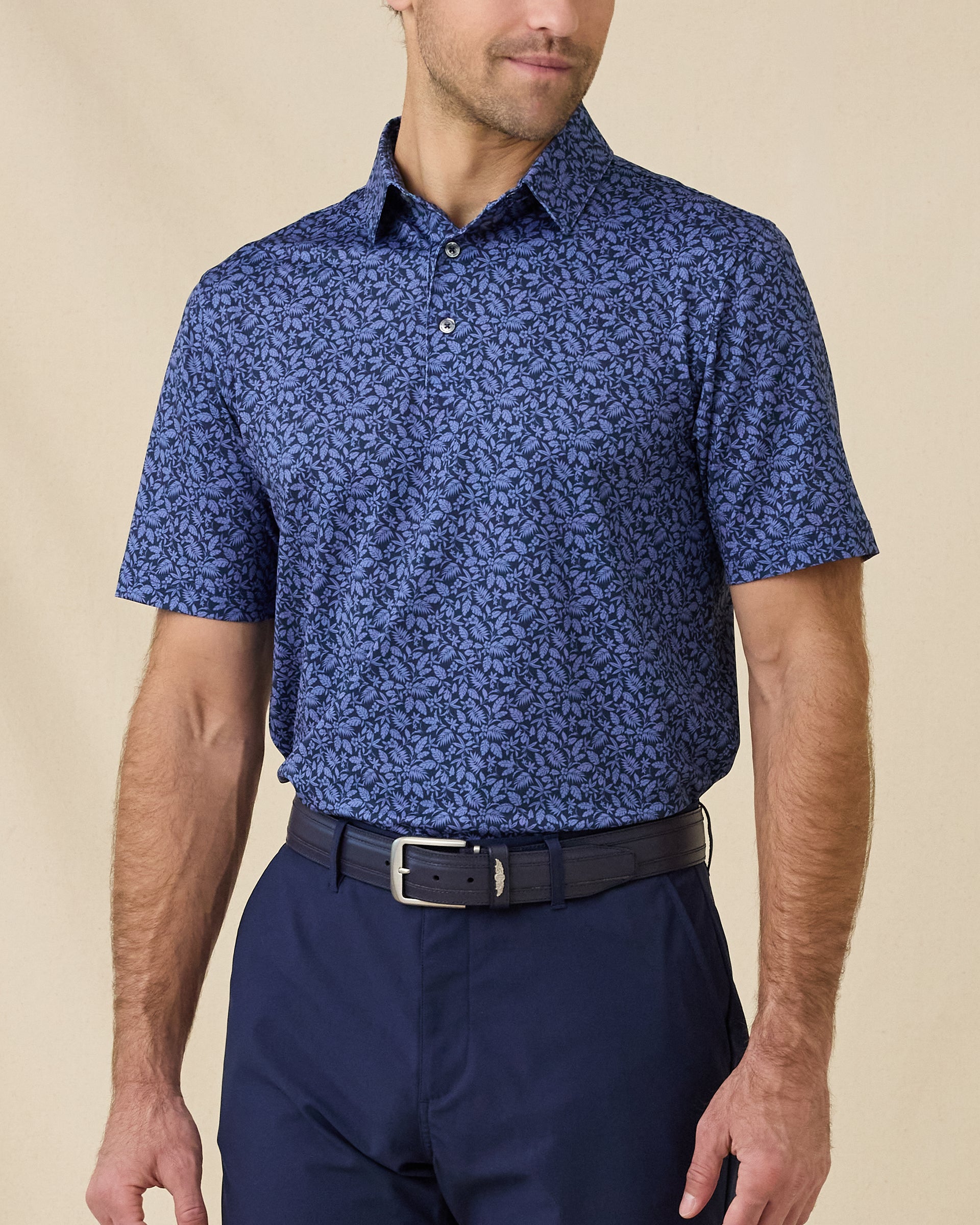 Model wearing the Tropics Lounge Polo in Tidal Blue, featuring a tonal tropical print
