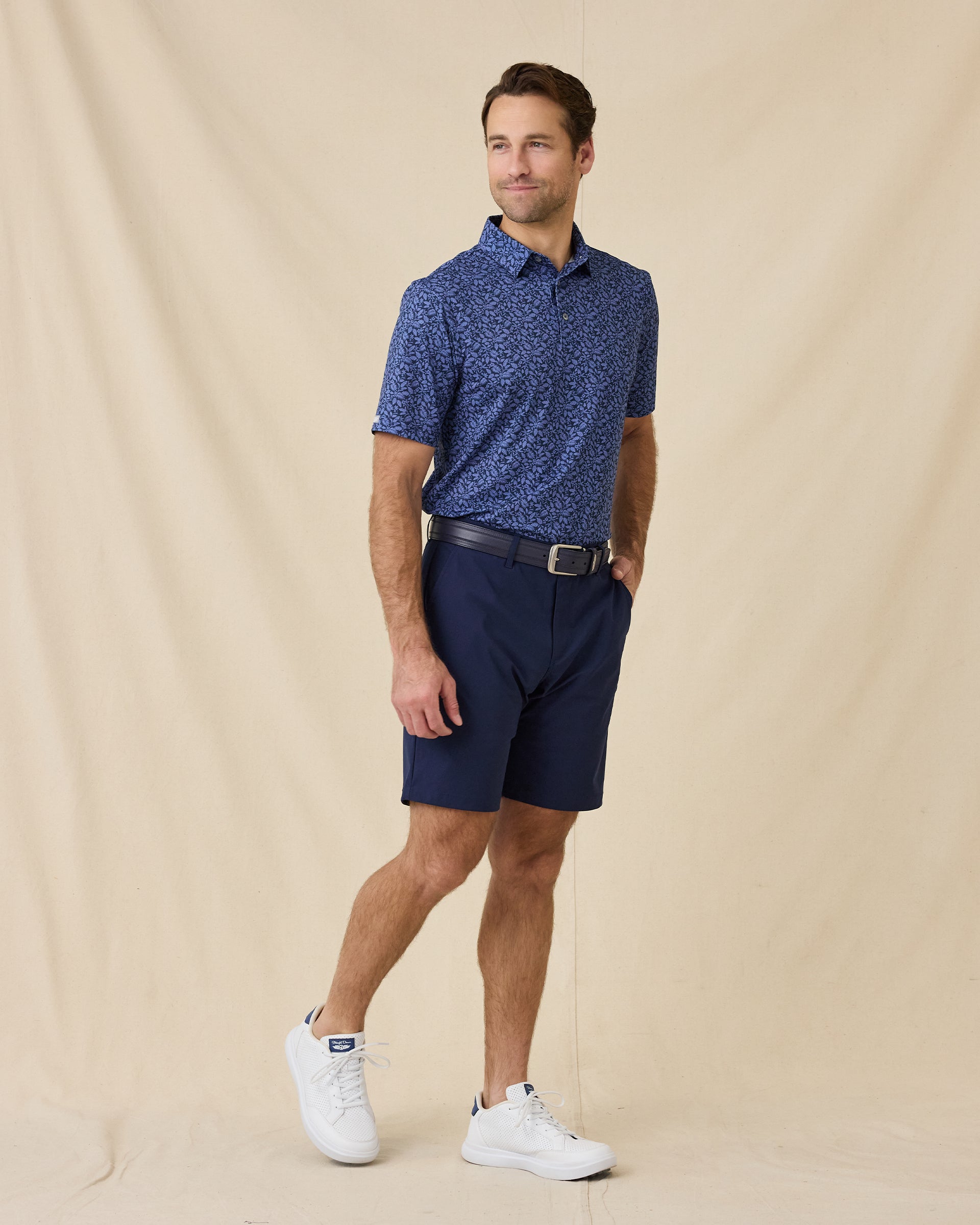 Model wearing the Tropics Lounge Polo in Tidal Blue paired with navy golf shorts