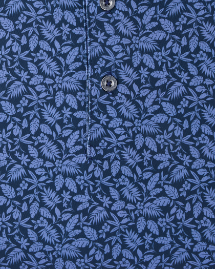 Close-up of the Tropics Lounge Polo in Tidal Blue highlighting the detailed tropical print in contrasting blue tones