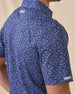 Side detail of the Tropics Lounge Polo in Tidal Blue showing the allover tropical pattern and Straight Down sleeve wings logo