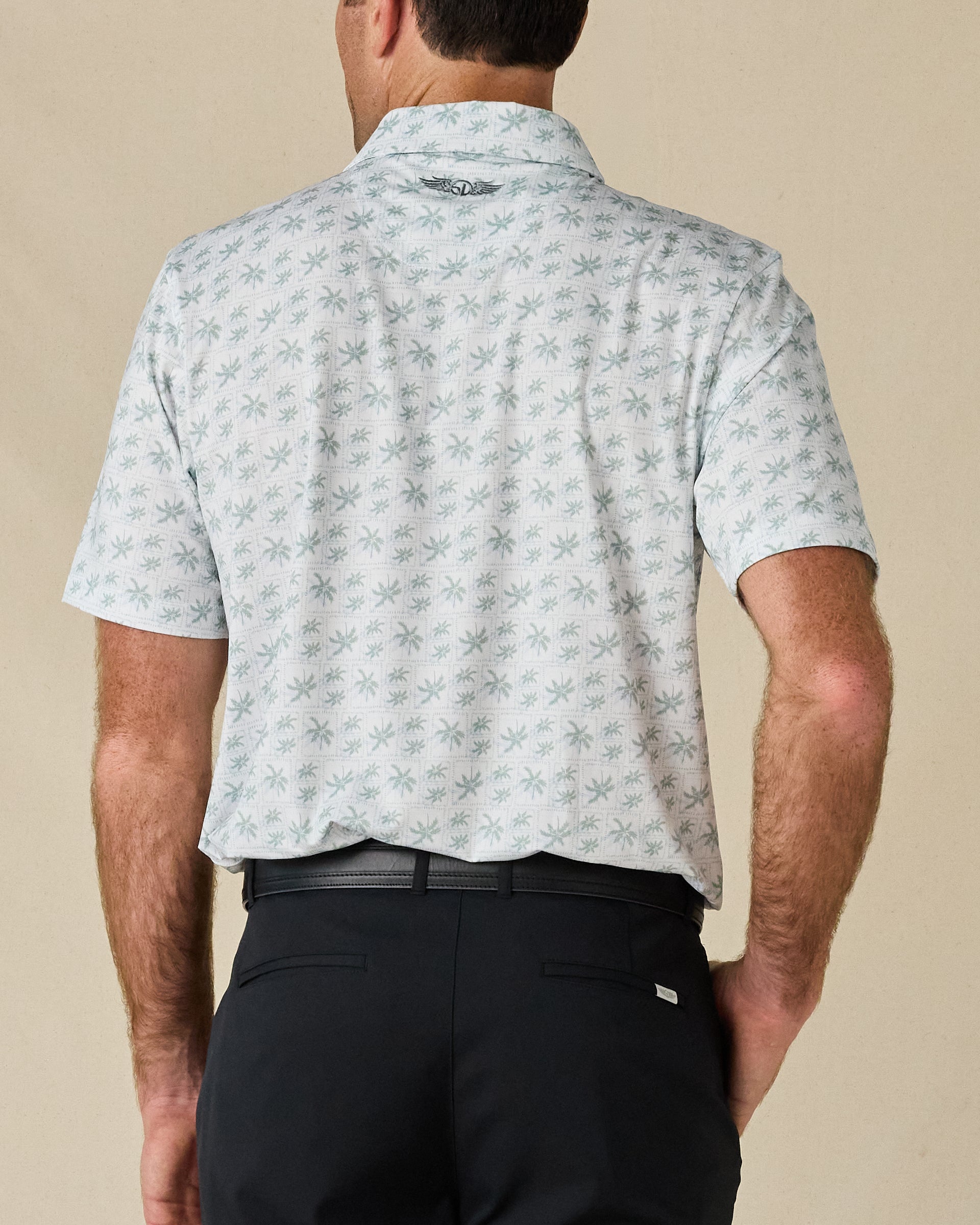 Rear view of the 29 Palms Polo in Herb, showing the palm print and embroidered logo below the collar.