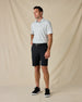 Model wearing the 29 Palms Polo in Herb with black shorts, a black belt, and black sneakers.