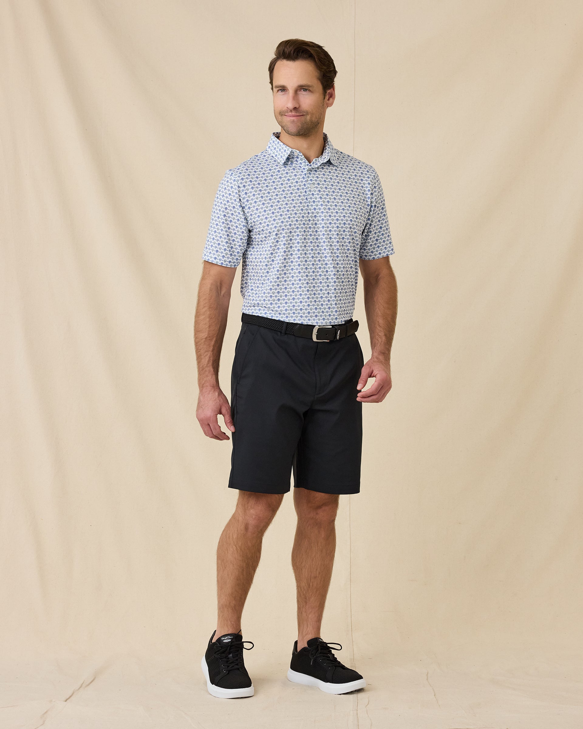Model wearing the Day of the Dead Polo in Herb with black shorts and black golf shoes.