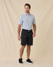Model wearing the Day of the Dead Polo in Herb with black shorts and black golf shoes.