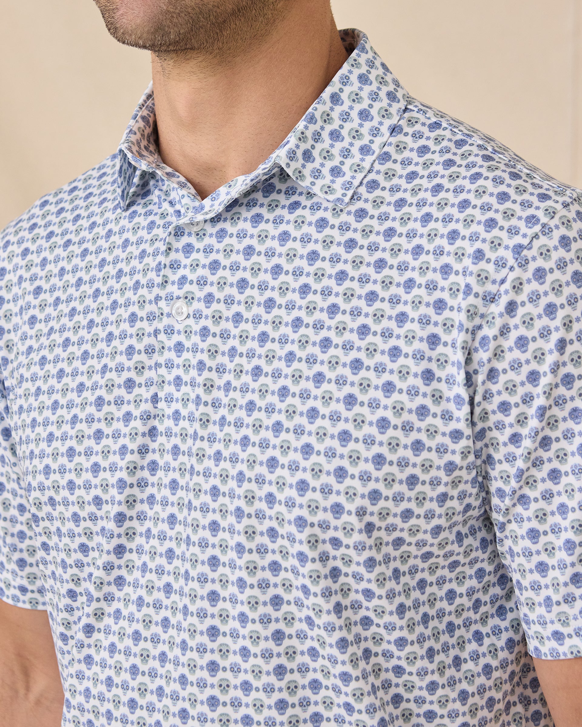 Close-up of the Day of the Dead Polo highlighting the blue and green sugar skull print, collar, and button placket.