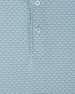 Close-up of a soft blue-green and white patterned button-down shirt fabric, showing a repeating cattle skull print and two white buttons on the placket.