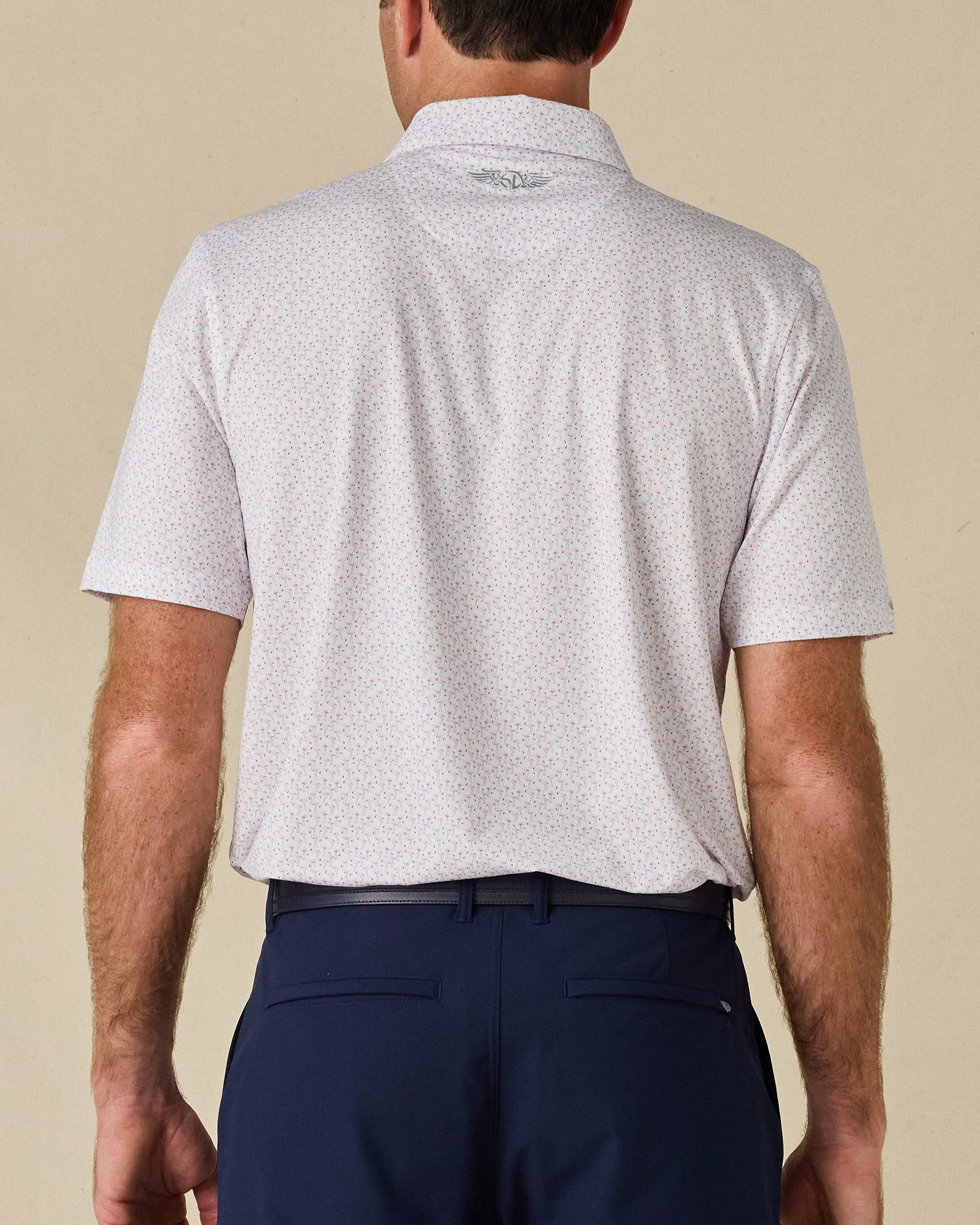 Back view of the Pink Flamingo Polo in Sea Shell, highlighting the all-over flamingo print and embroidered logo below the collar.