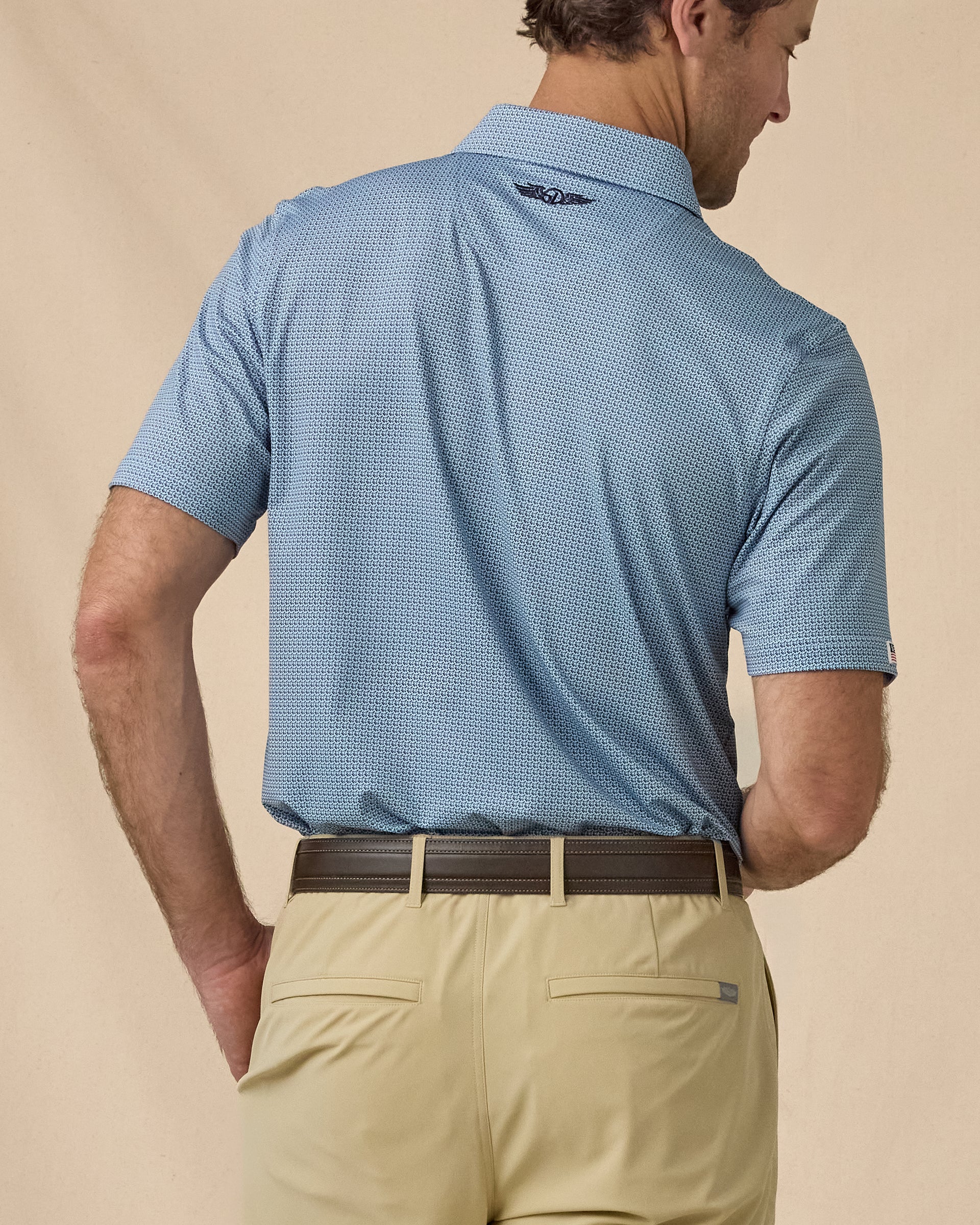 F-16 Polo in Nantucket Blue, angled back view paired with khaki shorts