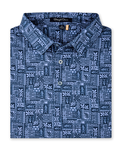 Folded Reef Runner Polo in Blue Shade, featuring an allover patchwork-inspired print with fish, florals, leaves, and geometric motifs.