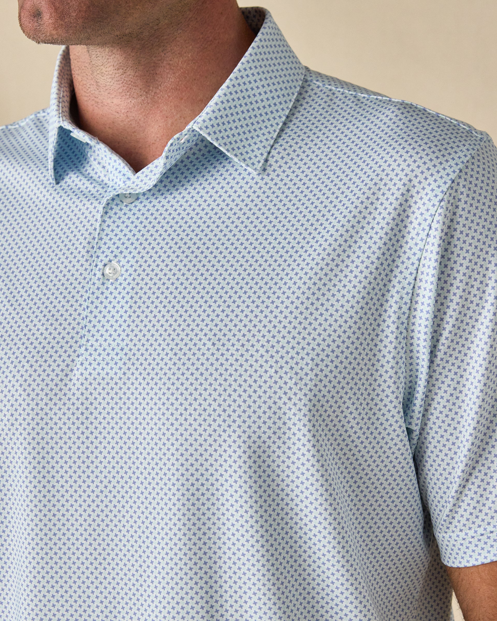 Close-up of the Check Mate Polo in Mint Tea, highlighting the small cross print, structured collar, and button placket.