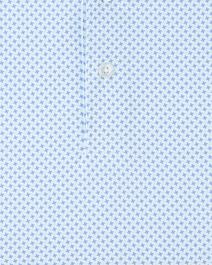 Close-up of the Check Mate Polo in Mint Tea, highlighting the repeating blue geometric pattern and branded button detail.