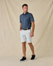 Model wearing the Banksville Polo in New Indigo with white golf shorts and black sneakers.