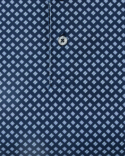 Close-up of the Banksville Polo in New Indigo, highlighting the repeating light blue geometric print and branded button detail.