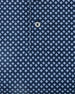 Close-up of the Banksville Polo in New Indigo, highlighting the repeating light blue geometric print and branded button detail.