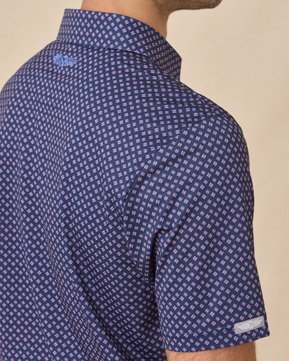 Side view of the Banksville Polo in Tidal Blue showing the geometric print, sleeve finish, and signature sleeve logo tab