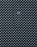 Close-up of the Banksville Polo in Black showing the light blue geometric print, placket stitching, and button detail.