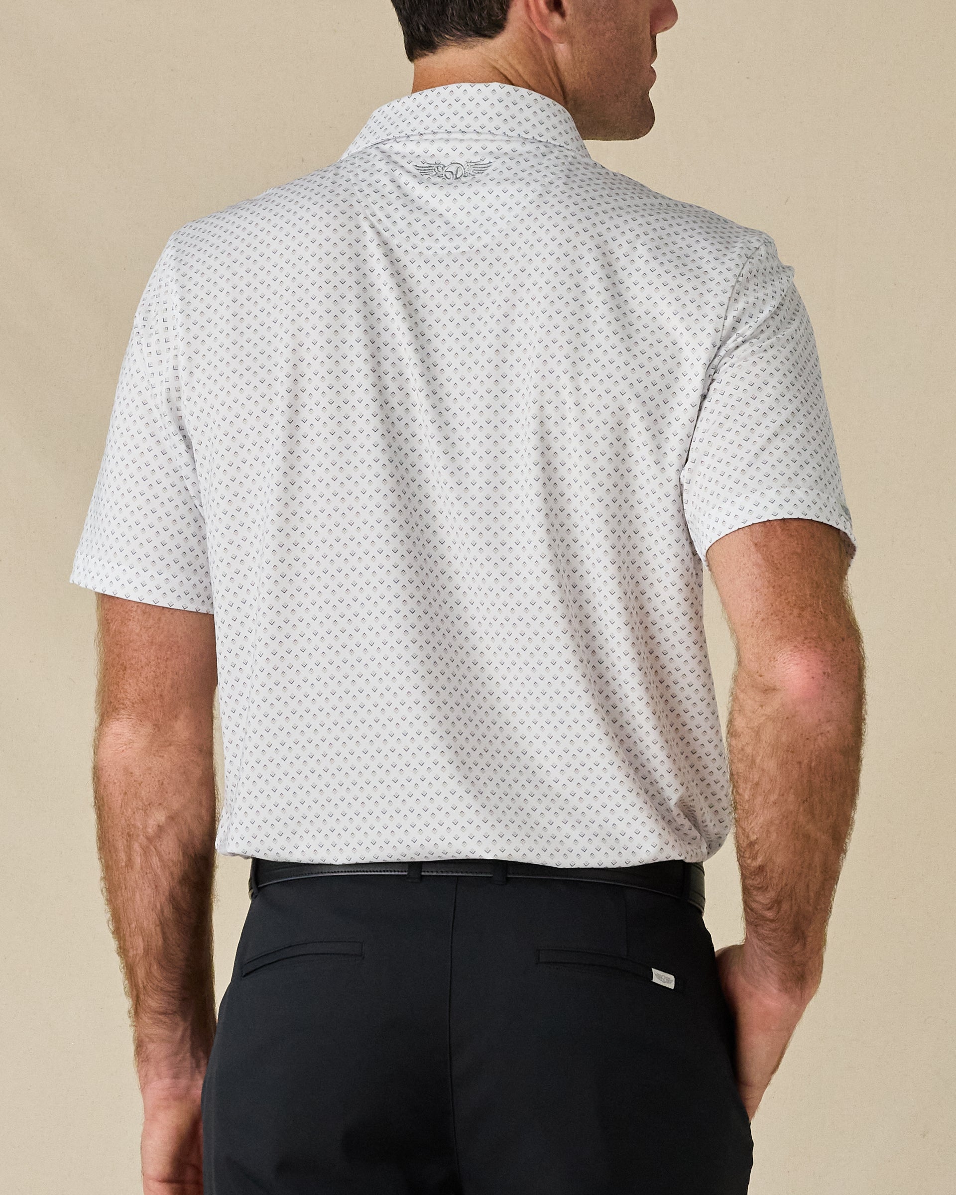 Rear view of the Brookhurst Polo in Herb, showing the small-scale geometric print and embroidered logo below the collar.