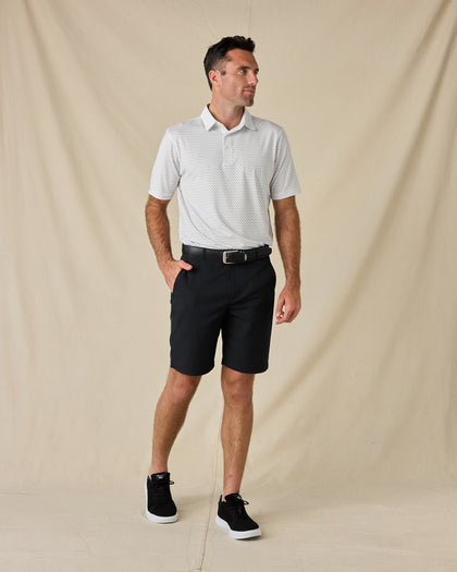 Model wearing the Brookhurst Polo in Herb with black shorts, a black belt, and black sneakers.