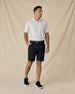 Model wearing the Brookhurst Polo in Herb with black shorts, a black belt, and black sneakers.