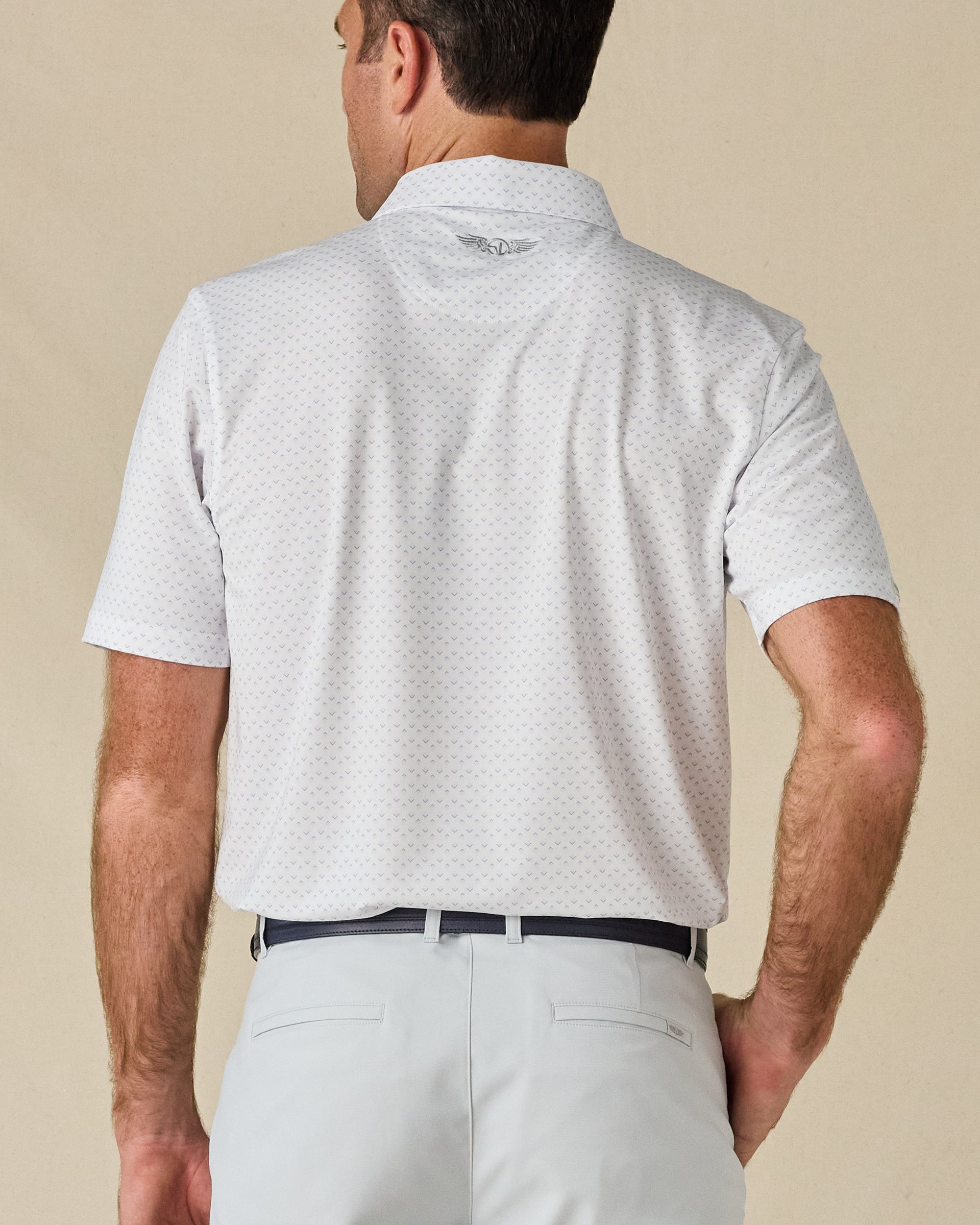 Back view of the Brookhurst Polo in Mint Tea, highlighting the subtle geometric print and embroidered logo below the collar.