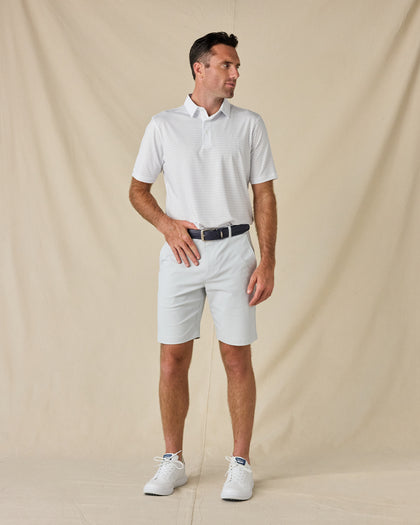 Model wearing the Brookhurst Polo in Mint Tea with light golf shorts, a navy belt, and white sneakers.