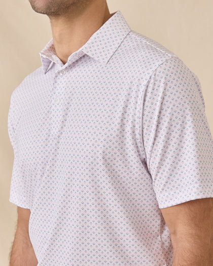 Close-up of the Brookhurst Polo in Punch Pink showing the geometric print, collar, and button placket details